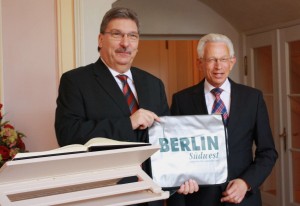 Mit einem kleinen Geschenk wurde Ralf Wieland von Bürgermeister Norbert Kopp in Steglitz-Zehlendorf willkommen geheißen. Foto: Gogol